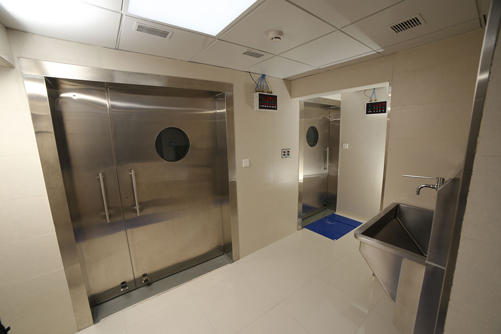 Theatre scrub corridor &mdash; stainless doors, controlled access